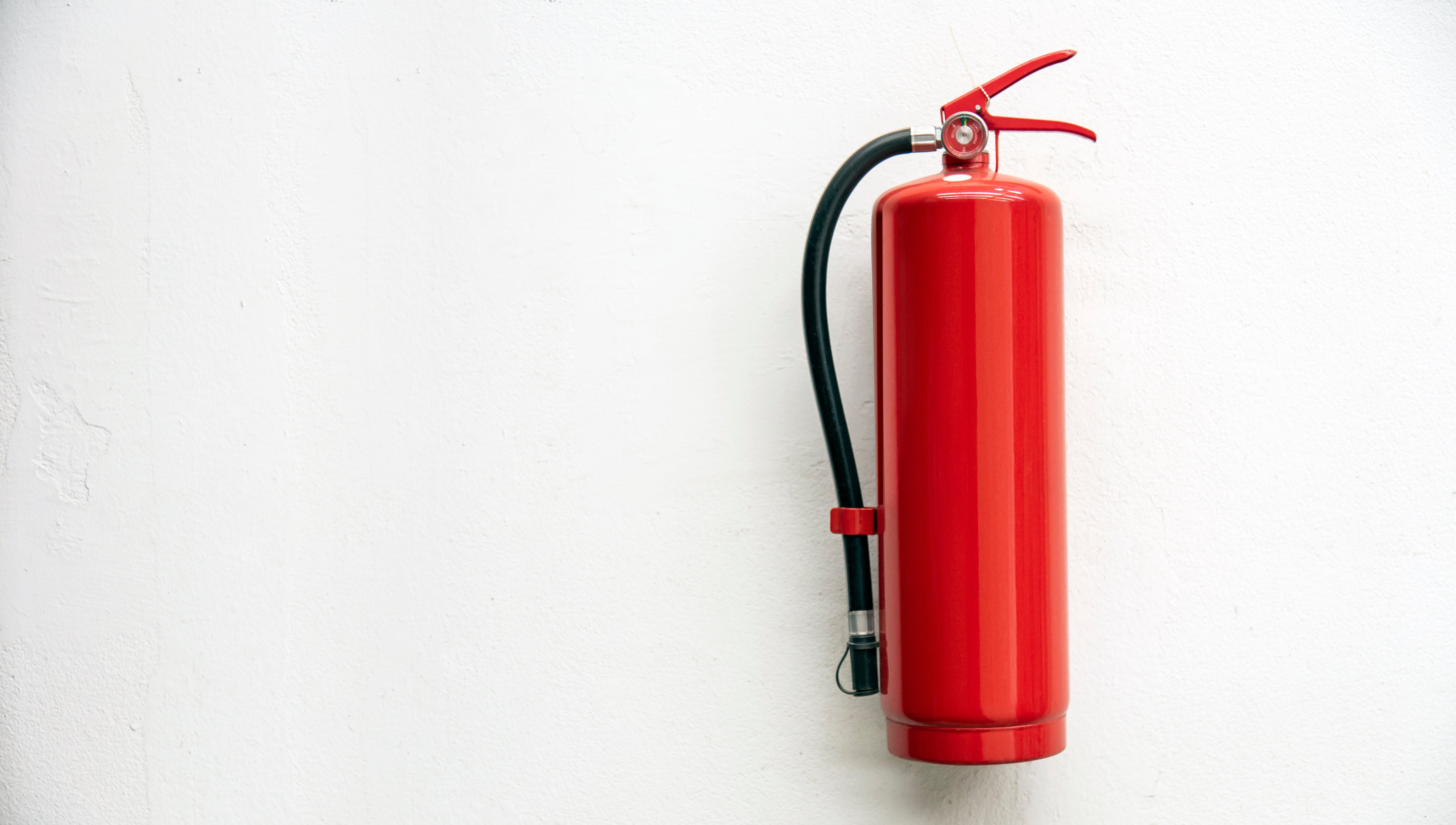 fire-extinguisher-on-white-concrete-wall-for-safet-FU87JS3